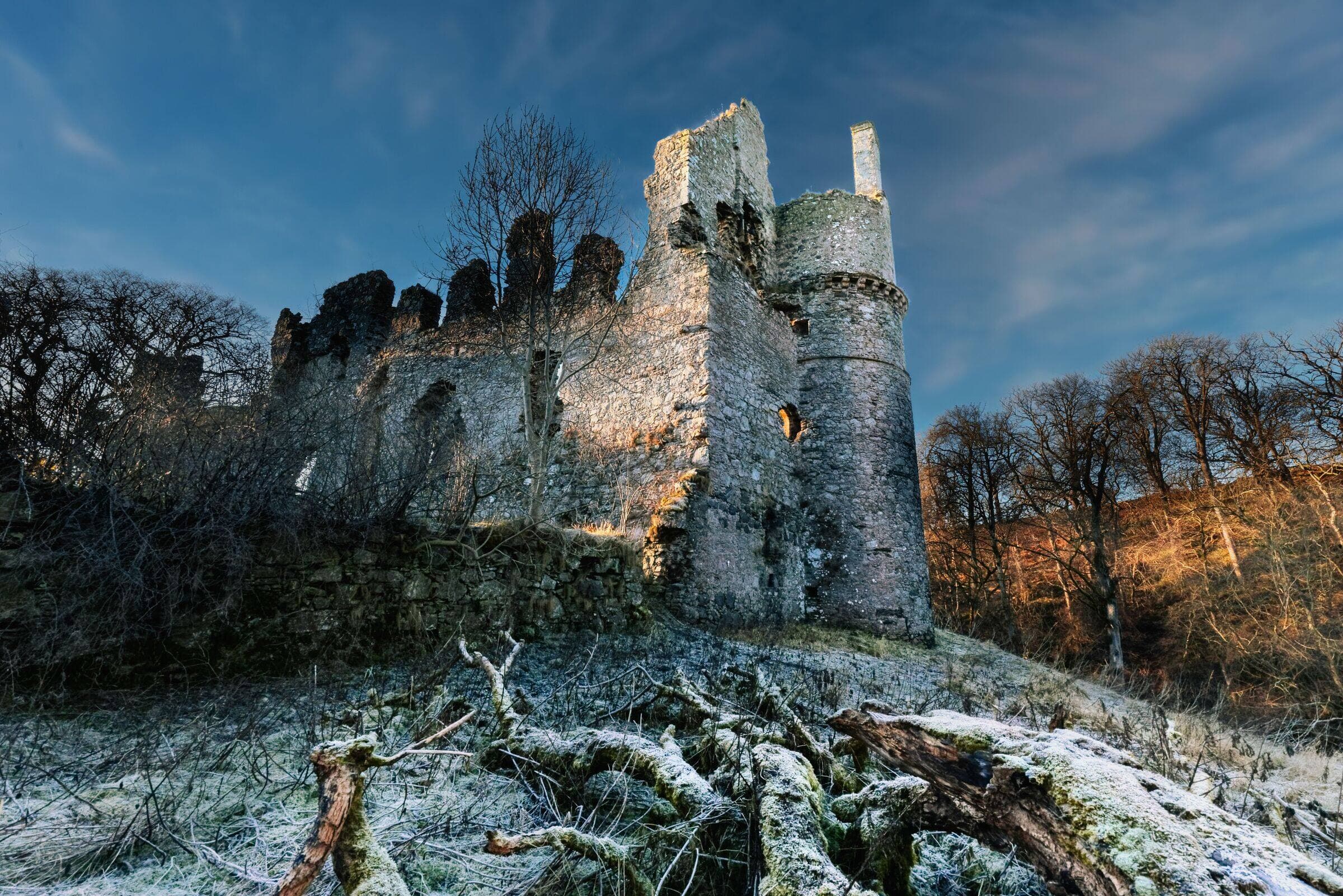 Eine schottische Burgruine an einem frostigen Morgen, der Stein von tiefer Wintersonne beleuchtet
