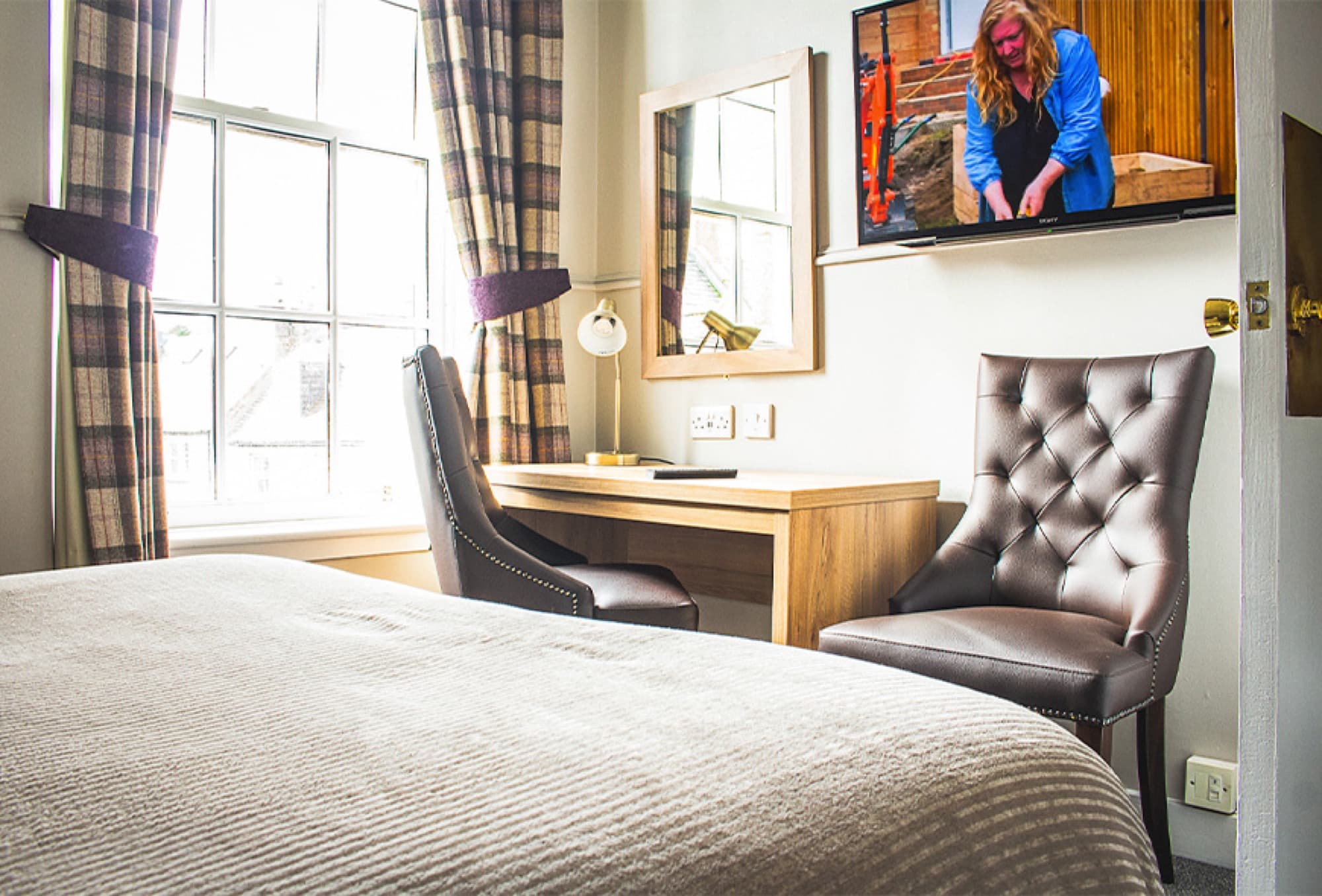 The bed, made up with tweed cushions